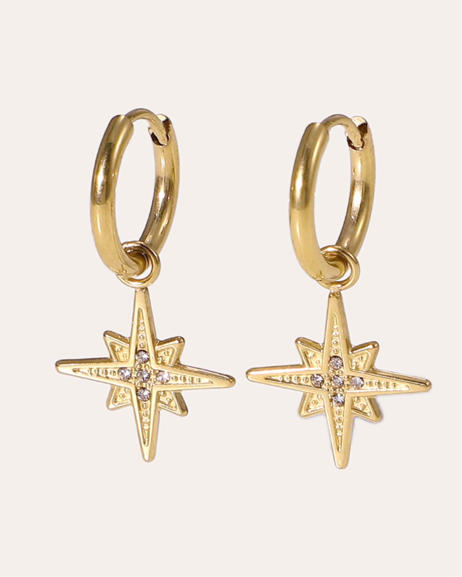 Shiny gold star charm earrings with sparkling zircon accents.